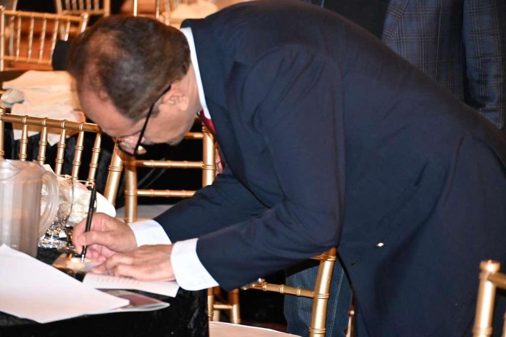 Amir Khan signing GRAVITAS book during the Bay Area Ceremony